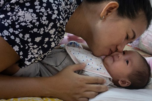 This photo taken on October 20, 2018 shows Panei Mon, wife of jailed journalist Wa Lone, cradling their two-month-old baby girl Thet Htar Angel in their Yangon apartment before leaving for a visit in Insein prison. Phyo Hein Kyaw/AFP