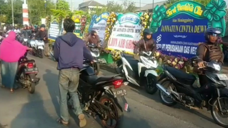 Motorcyclists walk their bikes past the home of Jannatun Shintya Dewi, the first victim identified from the crash of Lion Air JT-610, in Suruh Village, located in the East Java regency of Sidoarjo, Screenshot: Bahana Patria / Facebook