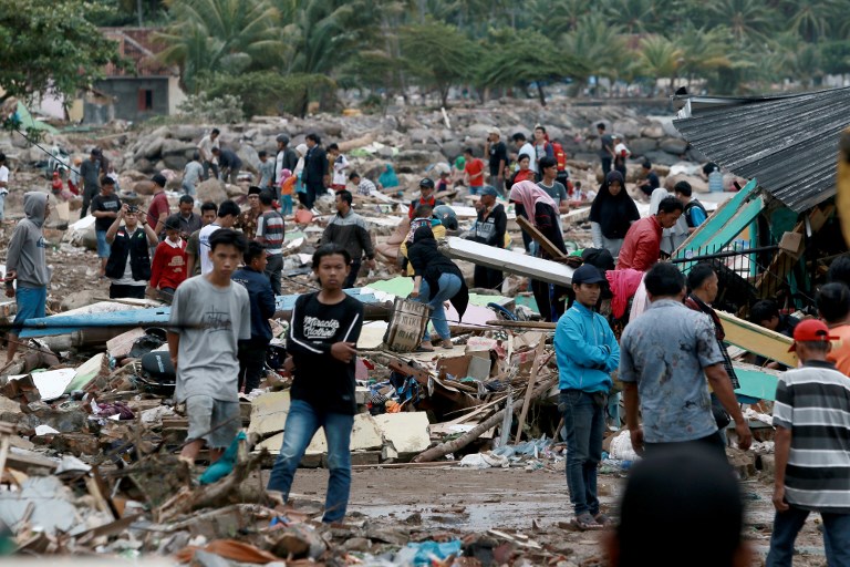 Rescuers and residents look for survivors along the coast in South Lampung on South Sumatra on December 23, 2018, after the area was hit by a tsunami on December 22 following an eruption of the Anak Krakatoa volcano. – A volcano-triggered tsunami has left at least 222 people dead and hundreds more injured after slamming without warning into beaches around Indonesia’s Sunda Strait, officials said on December 23, voicing fears that the toll would rise further. (Photo by Ferdi Awed / AFP)