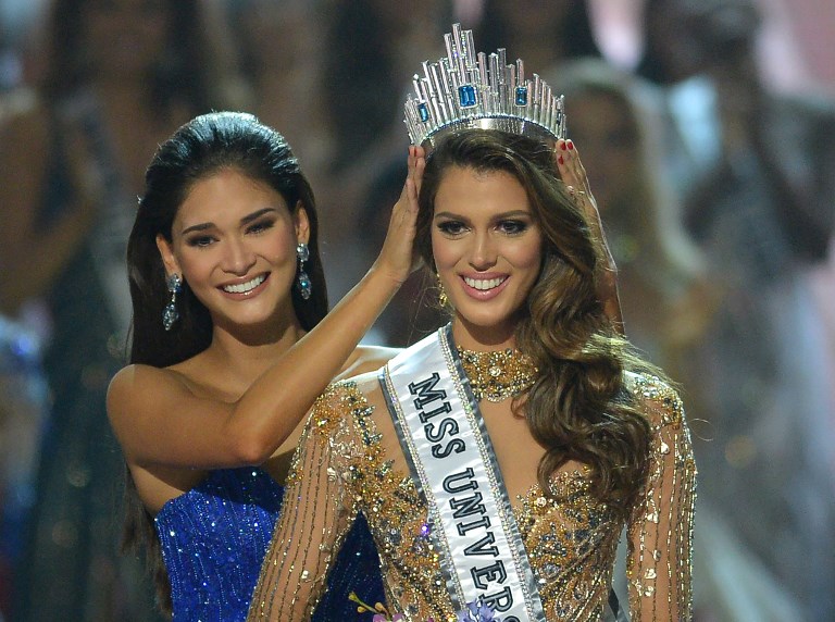 France's Iris Mittenaere (right) is crowned the 2017 winner in the Miss Universe pageant by Pia Wurtzbach of during the Miss Universe pageant at the Mall of Asia Arena in Manila on January 30, 2017. (Photo by TED ALJIBE / AFP)