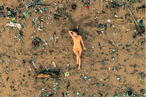 Olivia Dejeu posing on a trash-filled Batu Bolong beach. Photo via Instagram/ @thelifeofjord