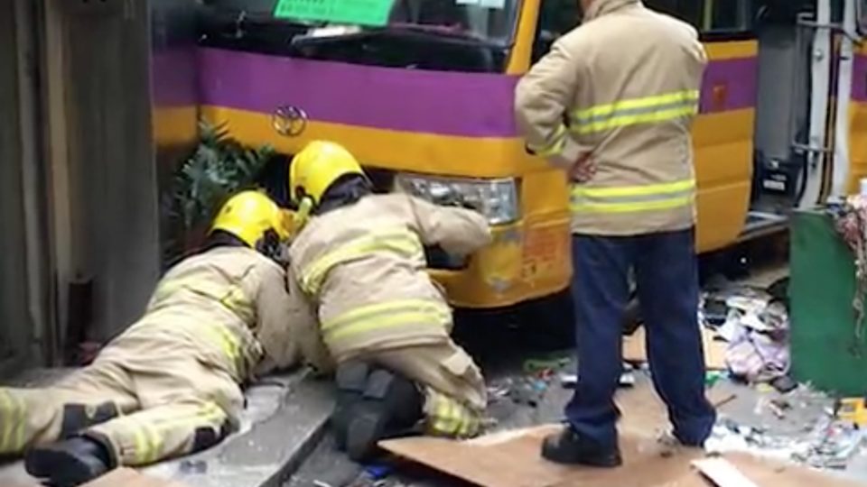 Firefighters work at the scene to free pedestrians mowed down by the minibus. Picture via Apple Daily video.