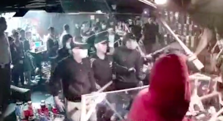 Men claiming to be members of the Sun Yee On triad destroy a DJ booth with baseball bats. Screengrab via Apple Daily video.