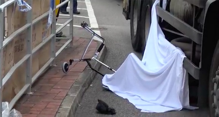 A white sheet covers the body of an elderly man who was hit by a garbage truck in Tsuen Wan. Screengrab via Apple Daily video.