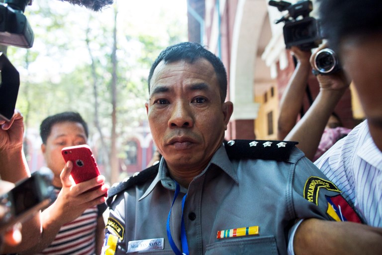 Myanmar deputy police major Moe Yan Naing (C) leaves the court following the ongoing trial of two detained journalists in Yangon on April 20, 2018. – A police official involved in a sting against Reuters journalists in Myanmar told a courtroom on April 20 that authorities set them up by handing over sensitive documents, a stunning admission that will tar the prosecution’s case. (Photo by Sai Aung MAIN / AFP)