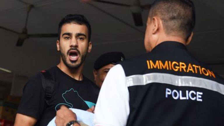 (FILES) In this file photo taken on December 11, 2018 Hakeem Alaraibi (C), a former Bahrain national team footballer with refugee status in Australia, is escorted by immigration police to a court in Bangkok. Activists for the detained Bahraini footballer who fears torture and even death if he is extradited from Thailand have criticised the “gagging” of talk about the case at the Asian Cup, warning it is harming his cause. (Photo by Lillian SUWANRUMPHA / AFP)