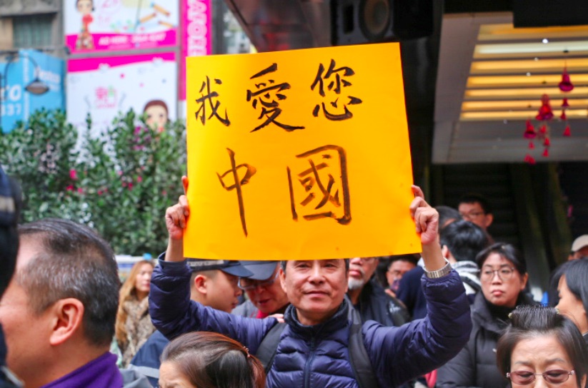 Pro-Beijing supporter Ngai Zi-long holding a placard that reads 'I love China'. Photo by Coco Gao.