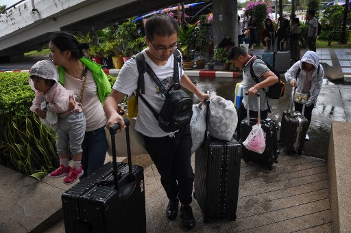 Chinese tourists disembark at Surat Thani airport after tour operators were forced to suspend boats to tourist islands due to tropical storm Pabuk, in the southern Thai province of Surat Thani on January 4, 2019. Photo by Lillian Suwanrumpha/AFP 