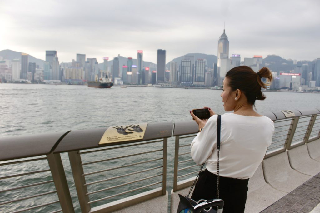 A tourist preparing to take a photo of Jackie Chan's handprints and plaque. Photo by Vicky Wong.