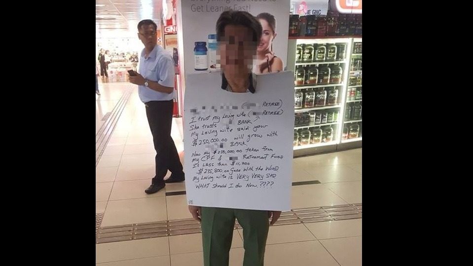 The man was spotted wearing a placard in the Raffles Place area demanding an explanation from a bank about his account monies (Photo: Shut down TRS / Facebook)