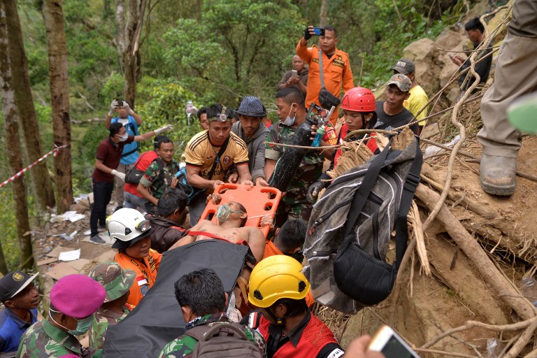 Members of an Indonesian search and rescue team carry a survivor after a mine collapsed in Bolaang Mongondow, North Sulawesi on February 28, 2019. – At least seven people died and dozens more are still trapped beneath the rubble of an illegal gold mine that collapsed in Indonesia, officials said on February 28, as rescuers frantically searched for survivors. (Photo by UNGKE PEPOTOH / AFP)