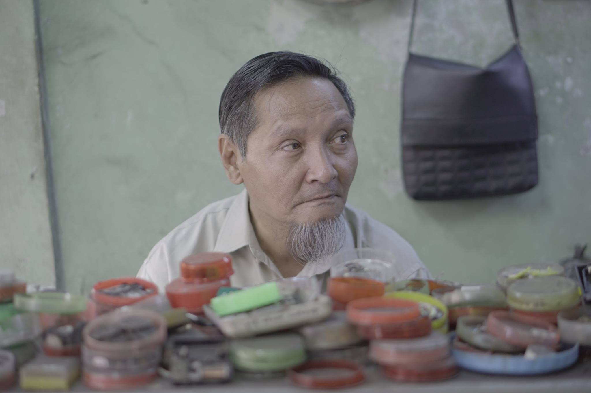 Ko Kyaw Oo sitting behind his station. Photo: Nay Paing/Coconuts Media. 