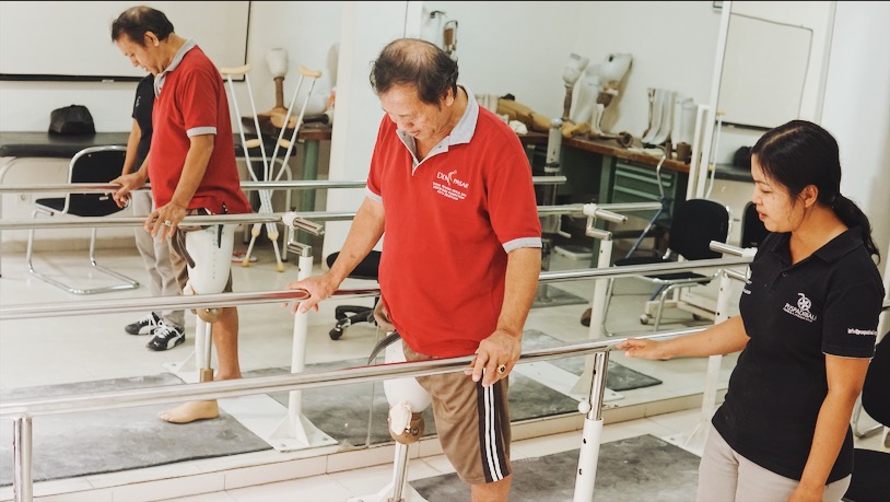 Tanty assists another rehab patient at Puspadi Bali. Photo: Julianne Greco/Coconuts Bali