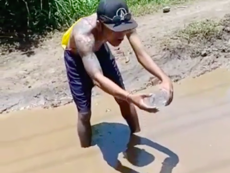 The Nusa Penida resident releasing fish into the 50-centimeter deep pothole. Photo: Still from the video posted by @bejust14