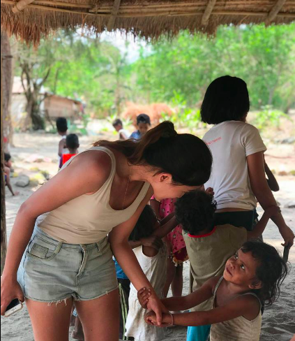 A Yangil kid holds the hand of one of the participants. Photo: Kaka Corral