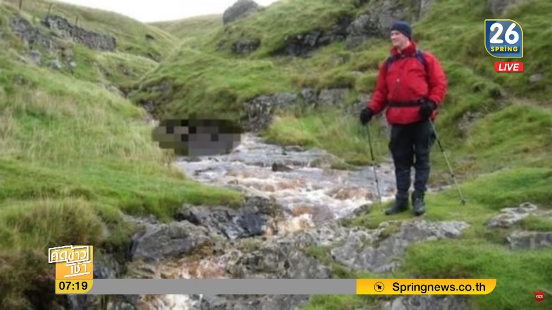 Hiker posing for a picture without realizing that Lamduan Armitage's body was behind him. Screenshot: Youtube/