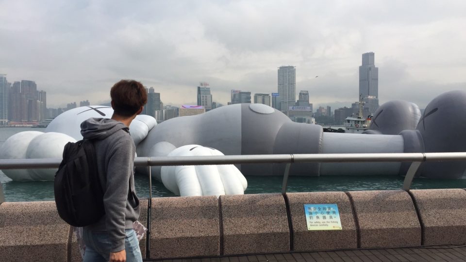 A pedestrian walks past the KAWS:HOLIDAY installation on Victoria Harbour earlier this week. Photo by Stuart White.