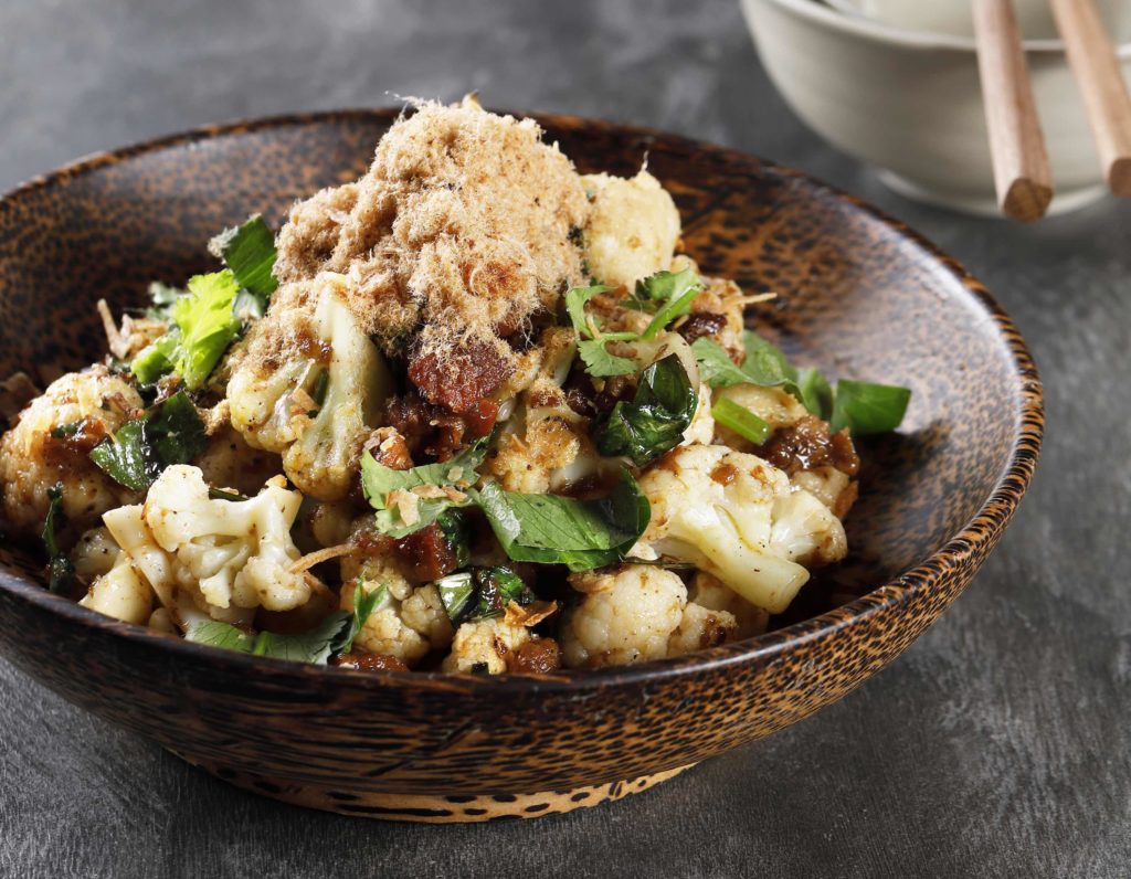 Nhau's sweet and spicy roasted cauliflower with caramelized pork koh quet. Photo via Nhau.