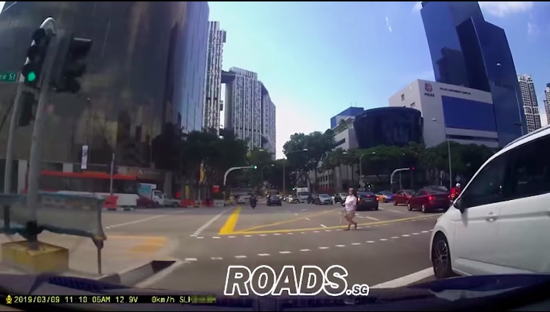 Just an old lady crossing the road while the traffic lights are green in favour of the cars (Photo: ROADS.SG / Facebook)