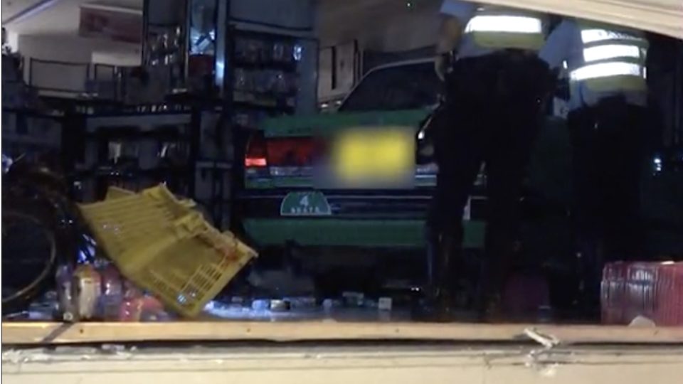 Police arrive at the scene of a Sasa comsmetics store in Sheung Shui where a cab rammed through the store front in the early hours of this morning. Screengrab via Apple Daily video.