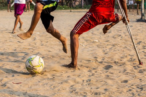 This photo taken on April 2, 2019 shows Kaung Khant Lin (R) playing football  with his friends in Yangon. – Football-mad Myanmar teen Kaung Khant Lin roots for Manchester United, worships star Lionel Messi and was honoured as the best player in a recent tournament. (Photo by SAI AUNG MAIN / AFP) / TO GO WITH: Myanmar-health-sport-football-lifestyle, FEATURE by Richard Sargent