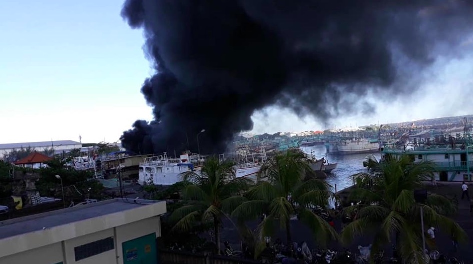 Thick clouds of smoke coming from Benoa Harbor on Saturday. Photo: Facebook/Noyan Bintang Sila
