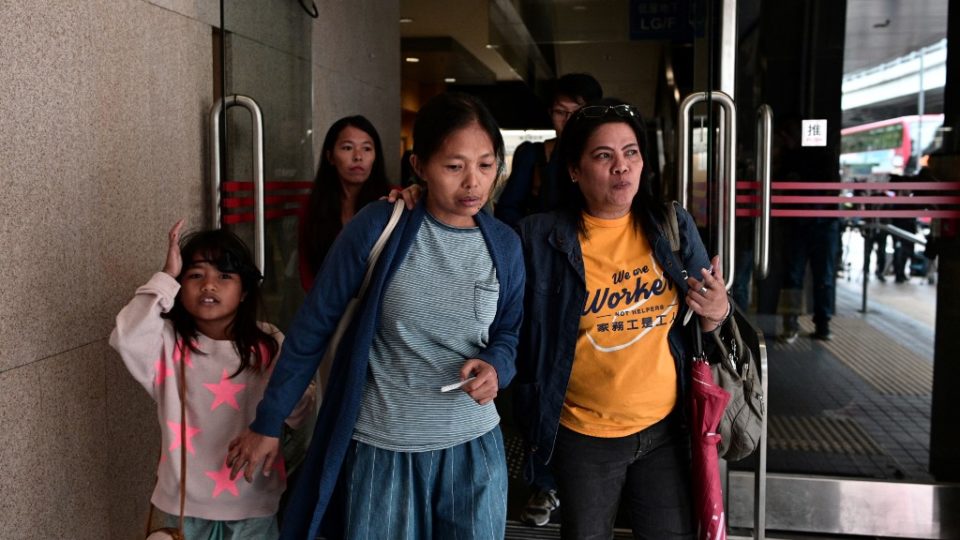 Baby Jane Allas (center) leaves with family members and supporters after a hearing at the Labour Tribunal in Hong Kong on Monday. Photo via AFP.