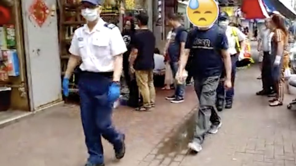 The victim of an attempted robbery is escorted by police in Tuen Wan yesterday. Screengrab via Apple Daily video.