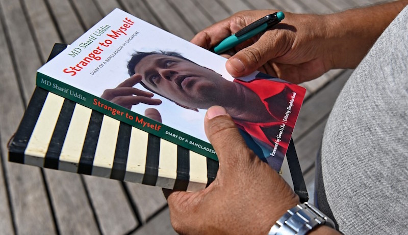 This photograph taken on April 15, 2019 shows Bangladeshi migrant worker M.D. Sharif Uddin holding his book and diary in Singapore. Photo: Roslan Rahman/AFP