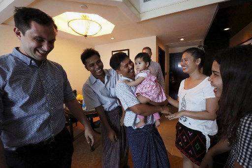 Reuters journalists Wa Lone (C) and Kyaw Soe Oo (2nd L) celebrate with family members after being freed from prison in a presidential amnesty in Yangon on May 7, 2019. – Two Reuters journalists who had been jailed for their reporting on the Rohingya crisis in Myanmar walked out of prison on May 7, freed in a presidential amnesty after a global campaign for their release. (Photo by ANN WANG / POOL / AFP)