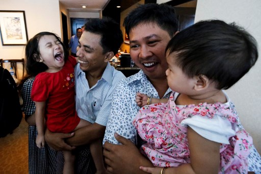Reuters journalists Wa Lone (R) and Kyaw Soe Oo celebrate with their children after being freed freed from Insein prison after a presidential amnesty in Yangon on May 7, 2019. – Two Reuters journalists who had been jailed for their reporting on the Rohingya crisis in Myanmar walked out of prison on May 7, freed in a presidential amnesty after a global campaign for their release. (Photo by ANN WANG / POOL / AFP)