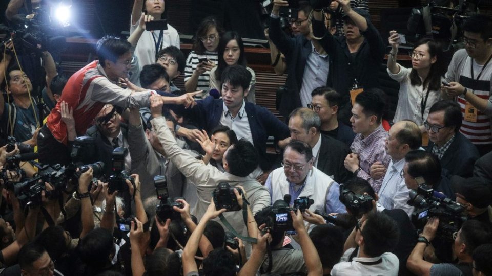 Hong Kong pro-Beijing lawmaker Abraham Shek (centre R-in white vest) is escorted from a legislative meeting after scuffles broke out between pro-Beijing and pro-democracy lawmakers in the Legislative Council (LegCo) in Hong Kong on May 11, 2019. – Anger over Hong Kong’s controversial plans to allow extraditions to the Chinese mainland boiled over in the city’s legislature on May 11 as rival lawmakers scuffled with each other in chaotic scenes. (Photo by STR / AFP)