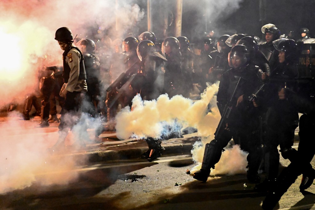 Indonesian police shoot tear gas to disperse protesters during a demonstration outside the Elections Oversight Body (Bawaslu) in Jakarta on May 22, 2019. – Heavily armed Indonesian troops were on high alert amid fears of civil unrest in the capital Jakarta, as the surprise early announcement of official election results handed Joko Widodo another term as leader of the world’s third-biggest democracy. (Photo by BAY ISMOYO / AFP)