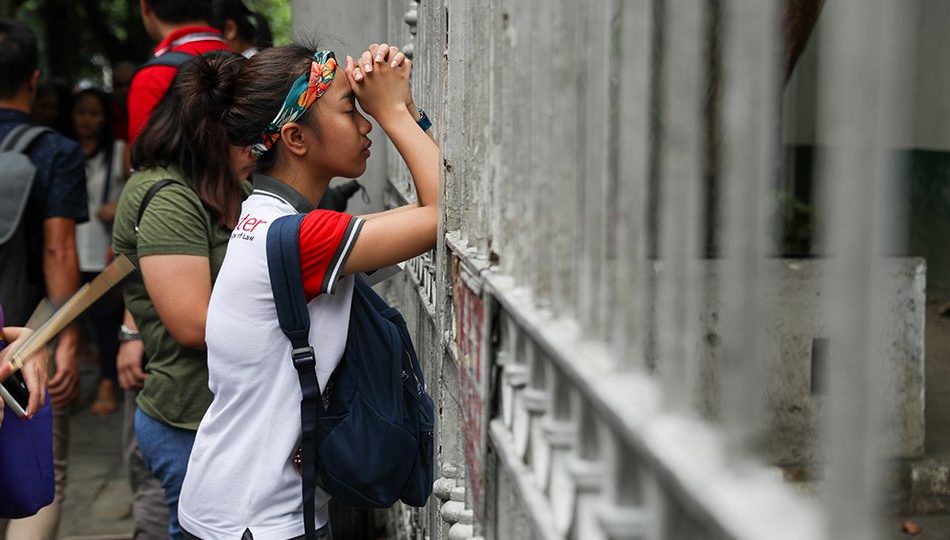 A woman prays while waiting for the results of the bar exams last year. Photo: Jonathan Cellona/ABS-CBN News