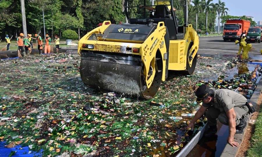 Indonesian workers destroy bottles of liquors from the recent raids in Jakarta on May 27, 2019. The Jakarta government destroyed about 1,800 bottles of liquors during the holy month of Ramadan.
ADEK BERRY / AFP