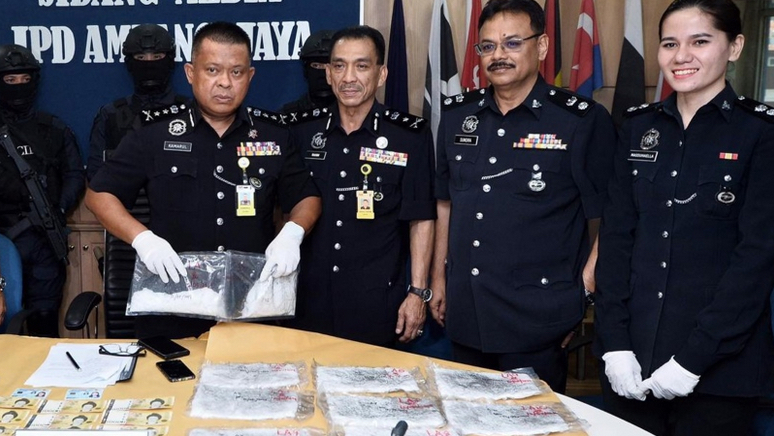 Satisfied Bukit Aman Narcotic Crime Investigation Department officers posing with their drug haul via Kosmo/PDRM