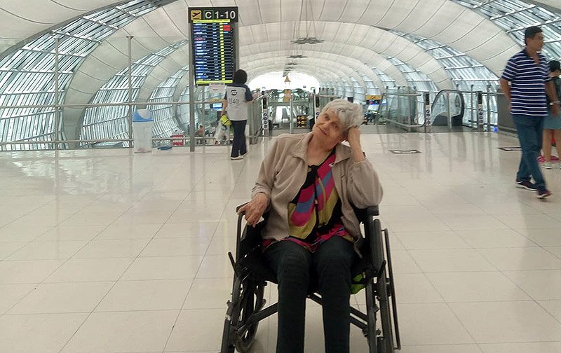 Anna Denis, 77, at Suvarnabhumi Airport on Tuesday in Bangkok. Her daughter said changes to immigration law has forced them to take her out of the nursing facility where she received 24/7 care for advanced Alzheimer’s in Chiang Mai and leave for the philippines while she can still travel. Photo: Deanna Denis