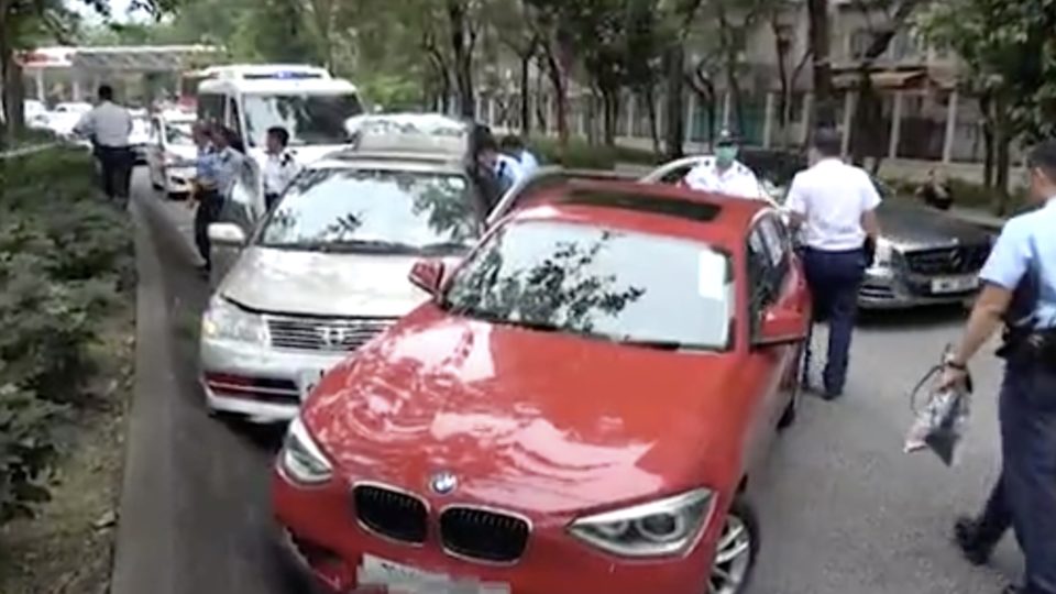 A man who attempted to steal a woman’s handbag was apprehended after the woman pursued him by hanging onto the steering wheel of his car, and her husband cornered him with his car. Screengrab via Apple Daily video.