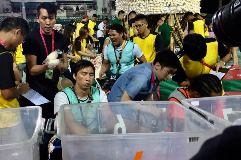 'King of Kings' Kwok Ka-ming (seated) recuperates after his championship bun run at the Cheung Chau Bun Festival on Sunday night. Photo by Stuart White.