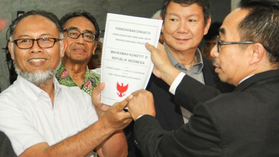 The brother of former general and president candidate Prabowo Subianto, Hashim Djojohadikusumo (2nd R), and their lawyer Bambang Widjojanto (L), submit a lawsuit to the constitutional court in Jakarta, on May 24, 2019, regarding a presidential election results dispute. Photo by Dany Krisnadhi/AFP 