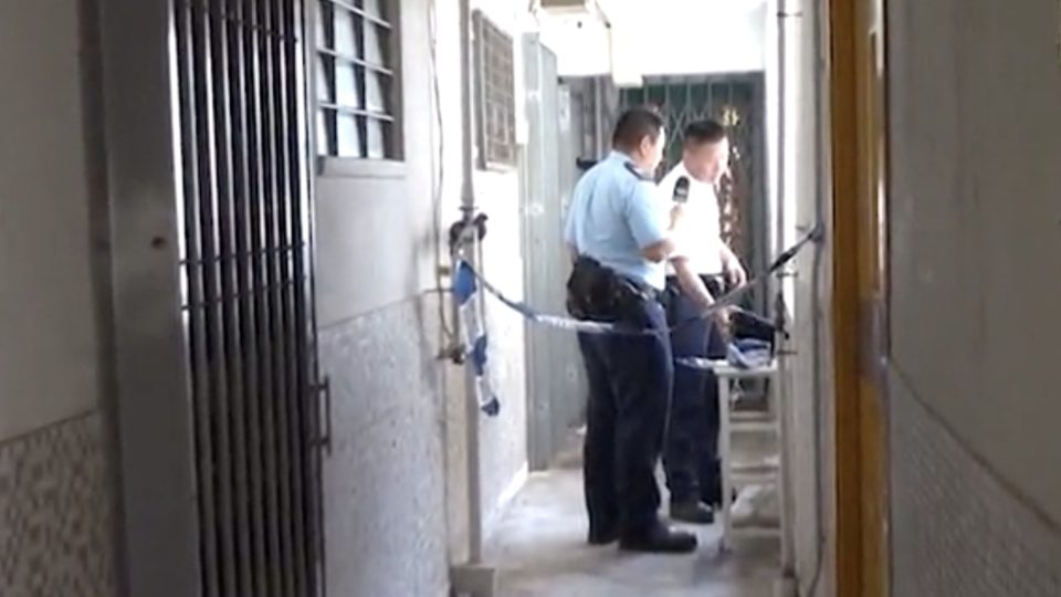 Police cordon off the apartment where a woman reportedly ran away from her boyfriend after he poured kerosene over her and threatened to burn her alive. Screengrab via Apple Daily video.