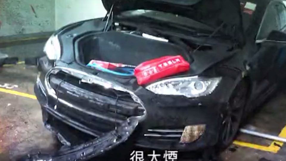 A Tesla Model S that apparently spontaneously caught fire in a Hong Kong parking lot in mid May. Screengrab via Apple Daily video.