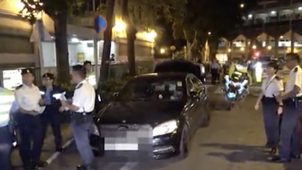Police at the scene where an officer shot at a driver that allegedly tried to run him over with his Mercedes Benz. Screengrab via Apple Daily video.