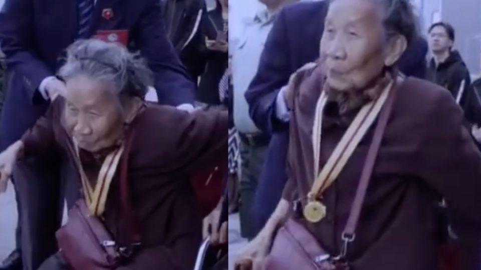 It’s a miracle! Woman gets up from wheelchair when the first few notes of the Chinese national anthem starts playing. Screengrab via YouTube.