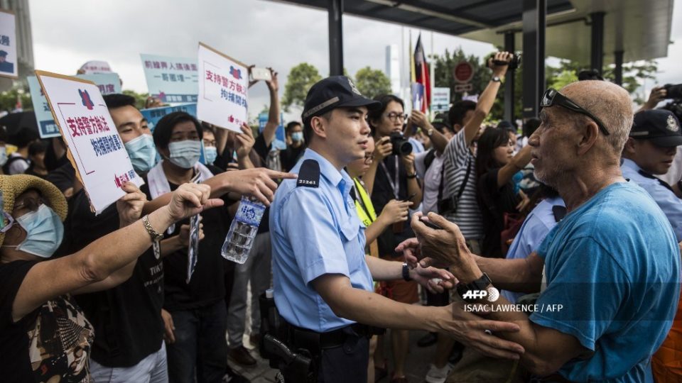 A police officer (C) separates pro-democracy protesters (L) and a pro-Beijing (R) supporter during a rally in support of police in Hong Kong on June 30, 2019. – The international finance hub witnessed the worst political violence in a generation as police fought largely young demonstrators opposed to a now postponed plan to allow extraditions to the Chinese mainland. (Photo by ISAAC LAWRENCE / AFP)