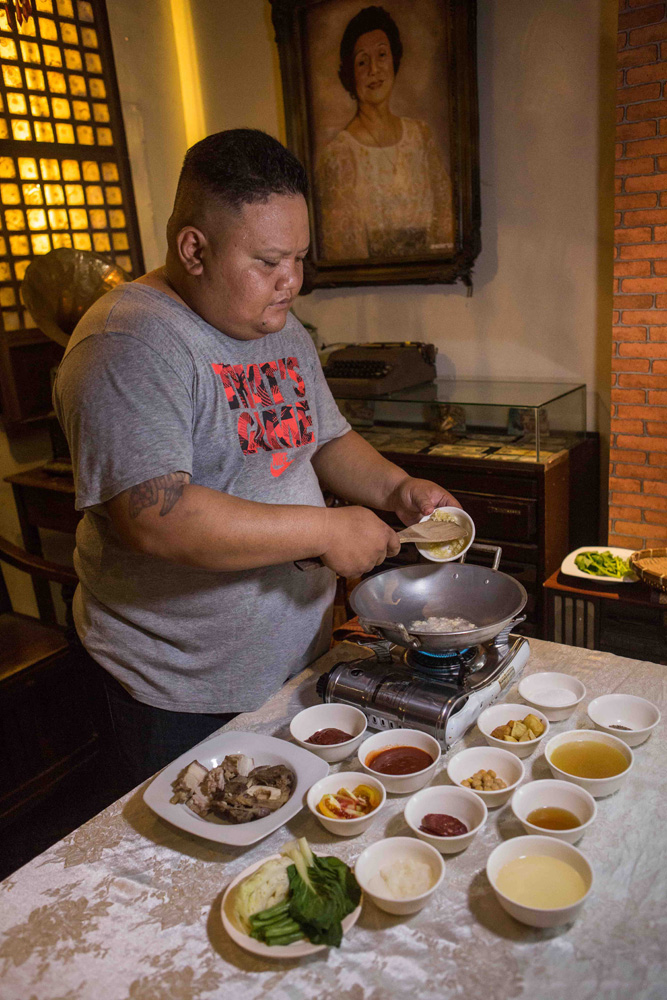 Niko Santiago cooking puchero. (Photo: Jacques Manuntag/Coconuts)