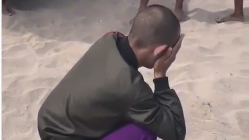 A screenshot of the video that has since gone viral showed Romy squatting while trying to cover his face, surrounded by a crowd. Photo: Denpasar Viral / Instagram