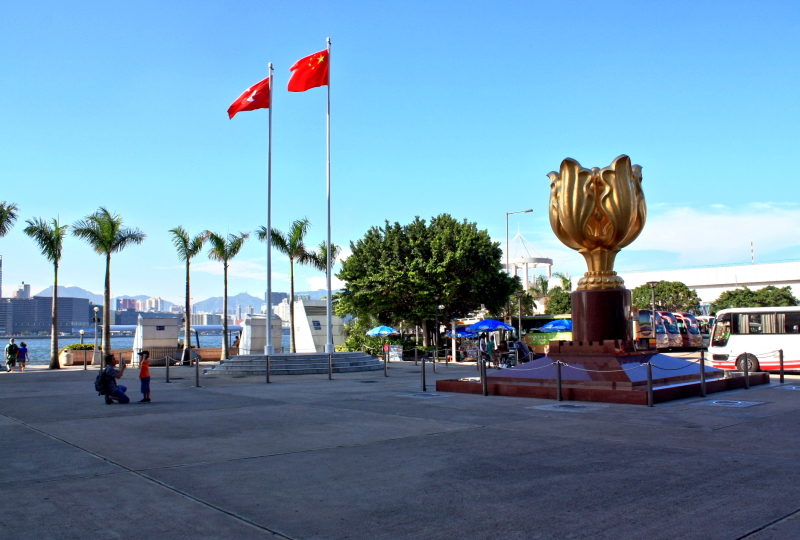 The Hong Kong and Chinese flags fly over Golden Bauhinia Square, the site of an annual ceremony marking the 1997 handover to China. Photo via Flickr/tszchungwing.