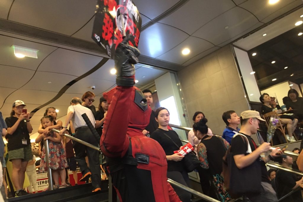 A man dressed as the comic book character Deadpool holds a sign depicting Chief Executive Carrie Lam impaled on a knife. Photo by Stuart White.
