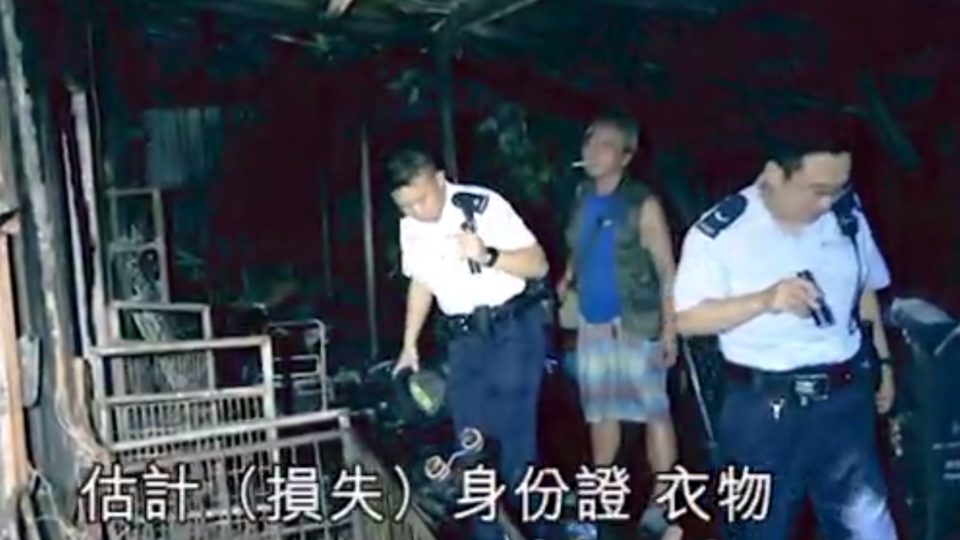 Authorities and the homeowner inspect the scene of a house fire in Tuen Mun believed to be caused by an exploding power bank that had been left to charge. Screengrab via Apple Daily.